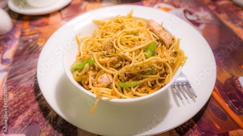 A dish of noodles with chicken and vegetables.