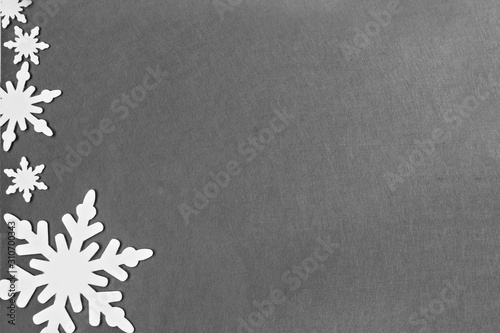 White felt snowflakes on a gray background. New Year card.