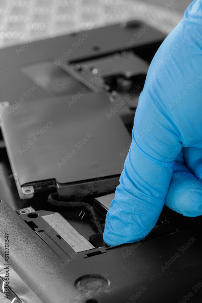 Technician connecting hard drive HDD cable to a laptop computer.  Computer updrade concept