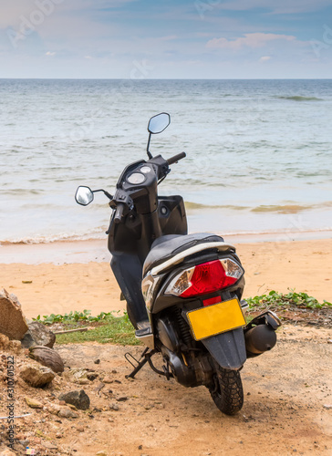 Lonely scooter on the sandy shore of the vast ocean, Sri Lanka