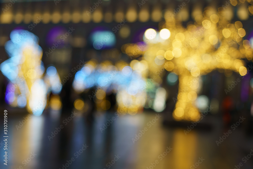 Fototapeta premium Nieostre zdjęcia świateł samochodów poruszających się nocą po ulicy miasta. Świąteczny nastrój, świąteczna atmosfera. Nadaje się jako szablon i tło dla pocztówek, kart okolicznościowych.