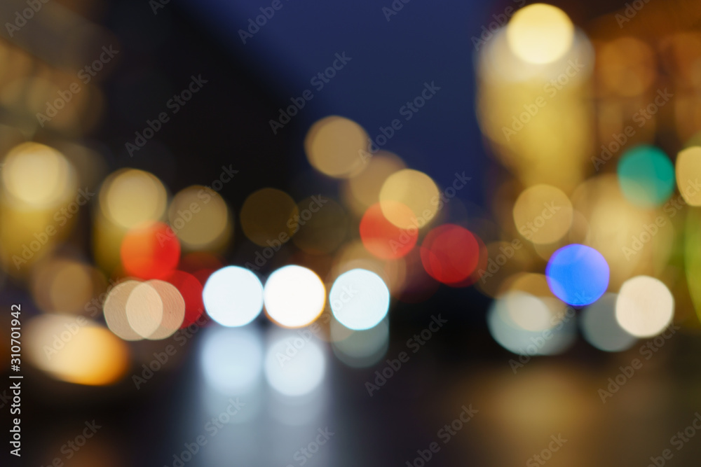 Defocused photography of lights on the cars in move on the city street in night. Christmas mood, festive atmosphere. Suitable as template and background for postcards, greeting cards.