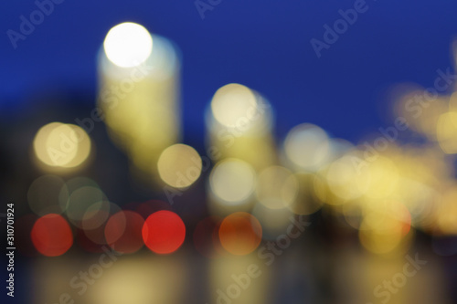 Defocused photography of lights on the cars in move on the city street in night. Christmas mood, festive atmosphere. Suitable as template and background for postcards, greeting cards.