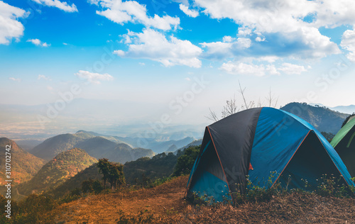 Temporary tent accommodation for tourists who like nature Located on high mountain with white clouds on blue sky and mountain range background, to travel on holiday concept.