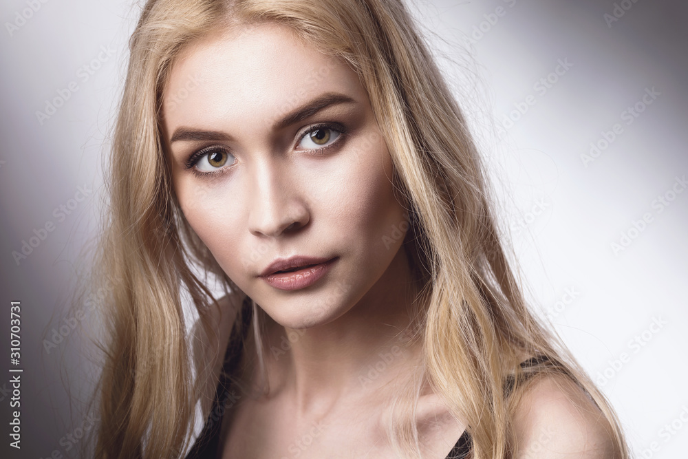 Portrait of a young beautiful blonde girl looking at the camera
