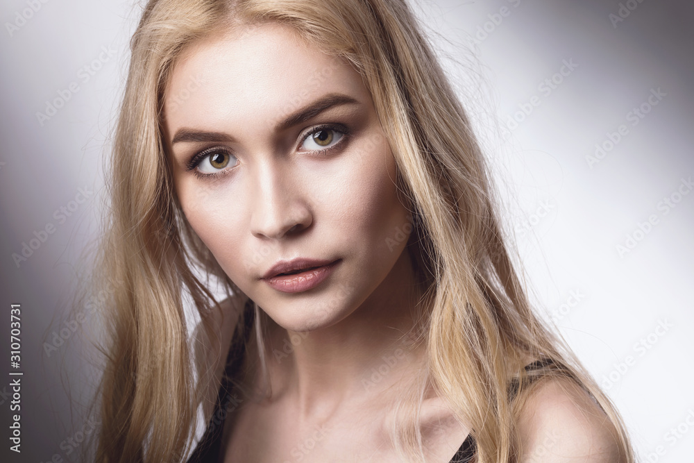 Portrait of a young beautiful blonde girl looking at the camera Portrait of a young beautiful blonde girl looking at the camera