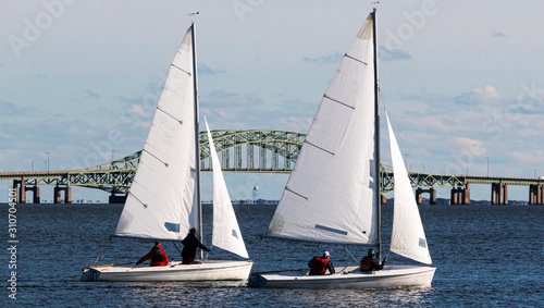 Two small sailboats with the Great South Bay bridge in background during December regatta