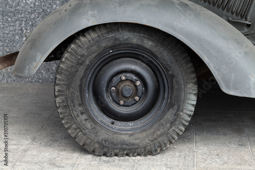 Close up photo of a black car wheel, old-timer