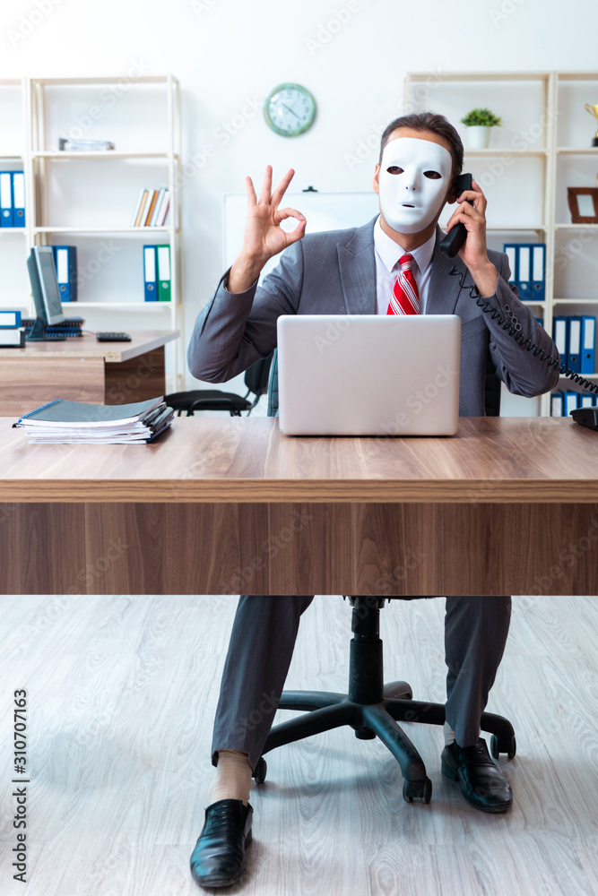 Businessman wearing mask in hypocrisy concept Businessman wearing mask in hypocrisy concept