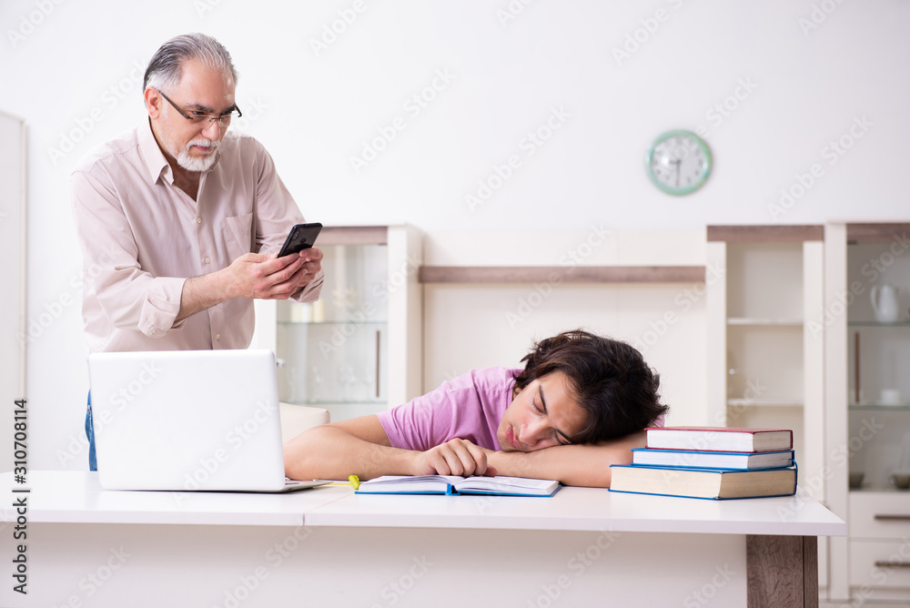 Fototapeta premium Old father helping his son in exam preparation