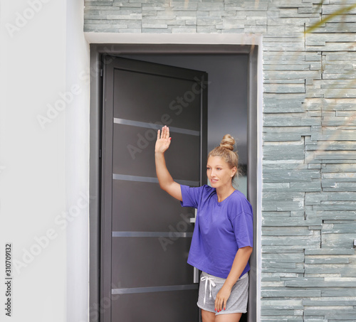 Beautiful woman opening the door of her home.Inviting the guests 