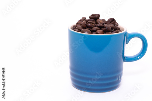 Coffee mug filled up with coffee beans