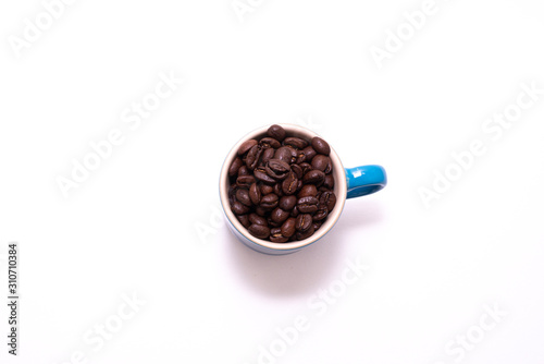 Coffee mug filled up with coffee beans