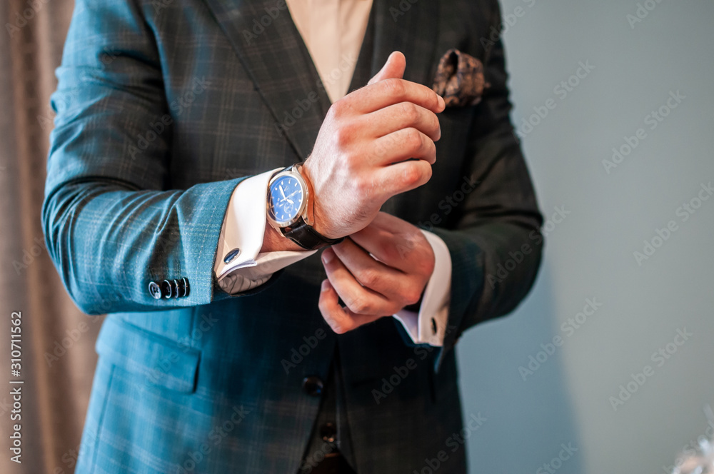 the groom puts a watch on his wrist
