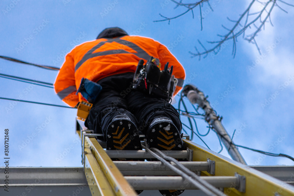 custom made wallpaper toronto digitalA professional telecoms installer is seen from directly below, installing fiber cables from the top of a ladder on the roof of a residential property