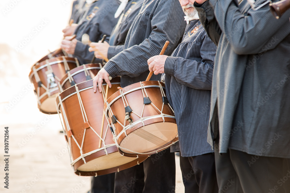 Men playing a typical percussion instrument of the celebration of the Fallas of Valencia, called 