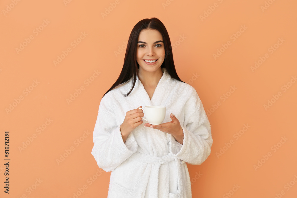 Beautiful young woman after shower drinking coffee on color background Beautiful young woman after shower drinking coffee on color background