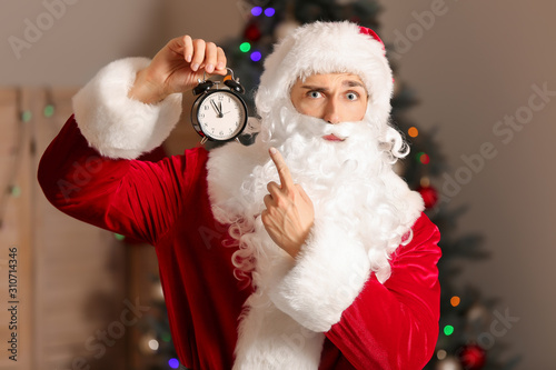 Santa with alarm clock in room. Christmas countdown concept