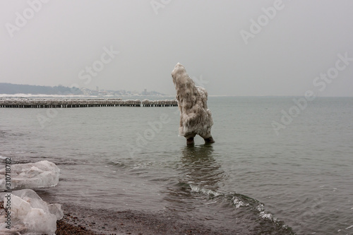 A strange ice figure coming out of the sea in winter