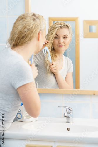 Woman brushing her wet blonde hair