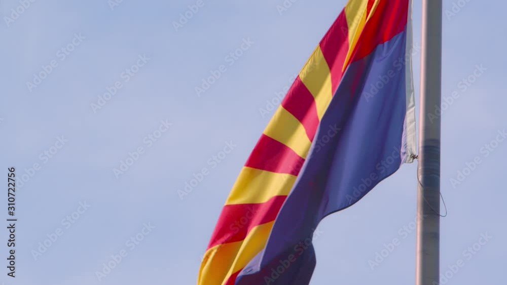 A backlit Arizona state flag blowing in the wind. A backlit Arizona state flag blowing in the wind.