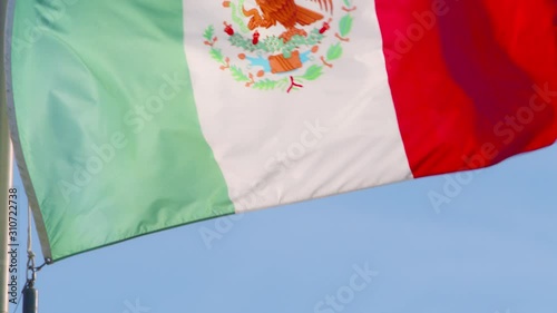 A backlit Mexican flag blowing in the wind. photo