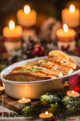 Photography Christmas dinner from fish salmon in roasting dish with festive decoration advent wreath and candles