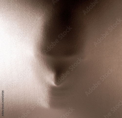 human face pressing through fabric as horror background