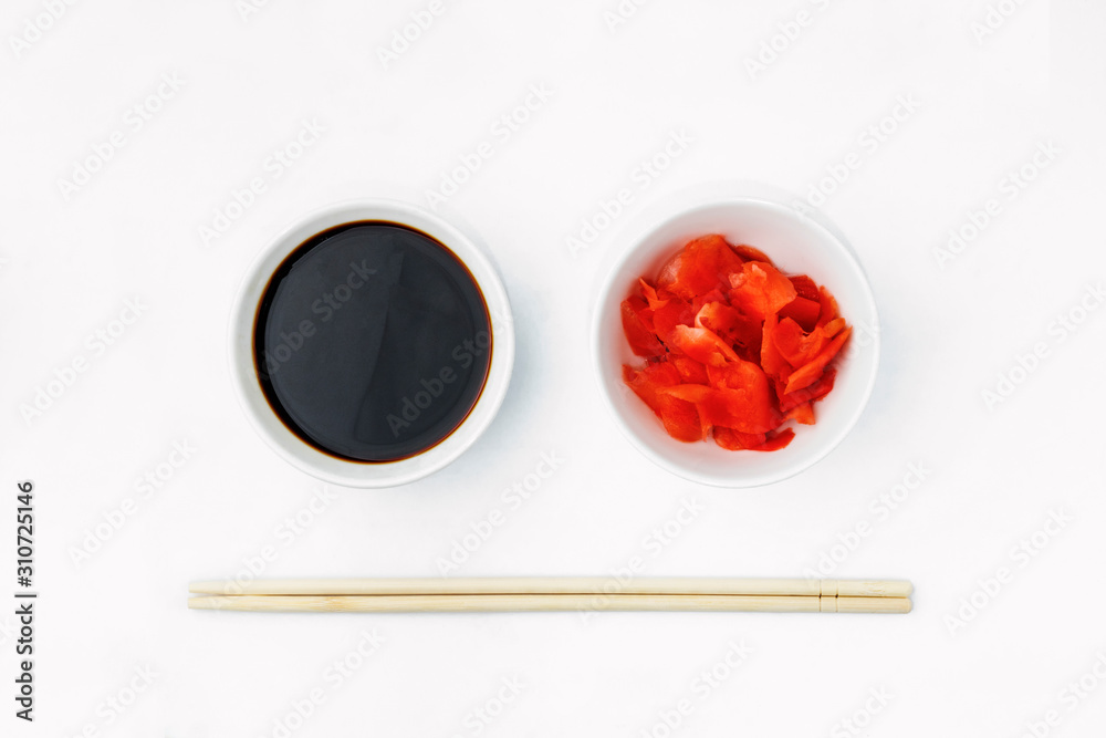 Funny face image of emoticon from soy sauce, pickled ginger and chopsticks, isolated on a white background. Creative oriental cuisine, restaurant concept. Copy space