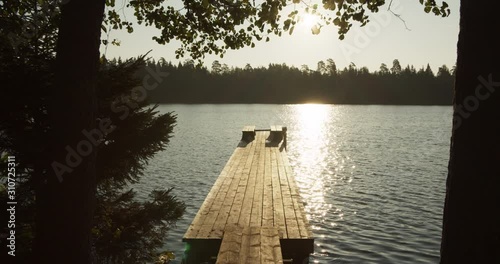 Wooden jetty pier on lake in sunny morning