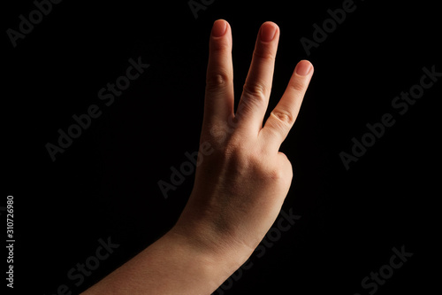 Numbers 3 in sign language. gesture number 3. hand gesture pay attention. women hand sign isolated on black background. finger pointer