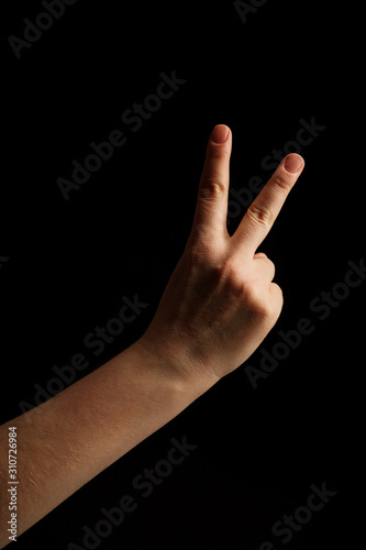Numbers 2 in sign language. gesture number 2 with hand sign. women hand sign isolated on black background. finger pointer