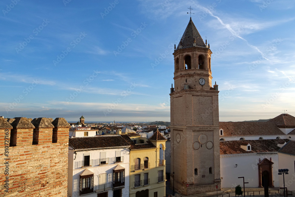 View from above overlooking the bell tower of San Juan Bautista and the roofs of the city of Velez-Malaga until the Mediterranean sea at blue sky, Andalusia, Spain, Europe