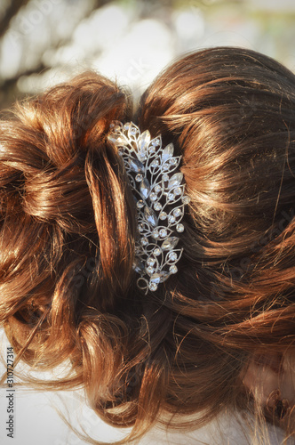 Hair styling. Festive hairstyle for the bride. Hair with a beautiful barrette.