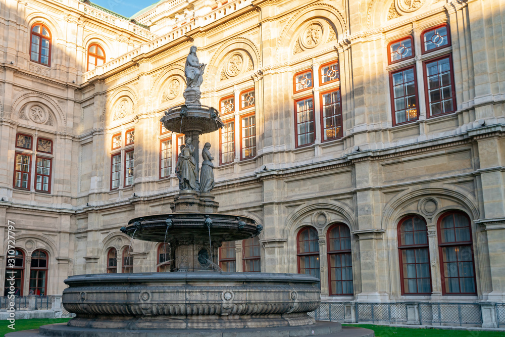 A fountain with Statues in front of the Opera in Vienna, Austria