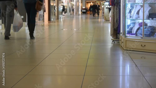 People Go In A Shopping Senter. Child Locomotive Drives On The Shiny Floor. photo