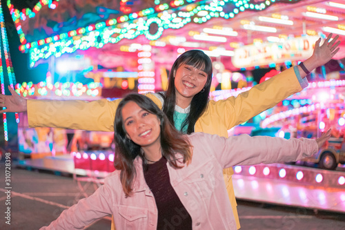 Canvas Print Women as friends visit fair at night and have fun together
