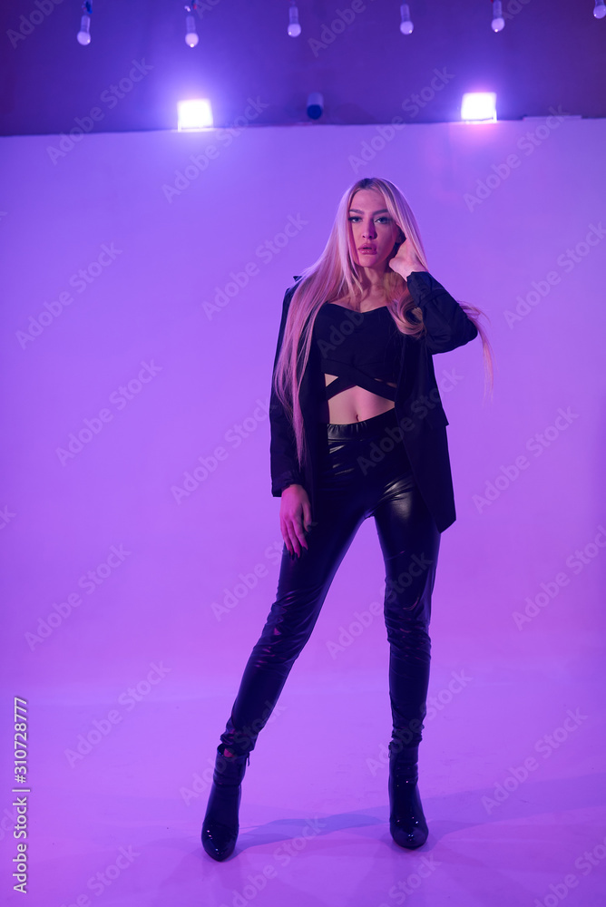 Attractive blonde woman sitting on the chair over pink background