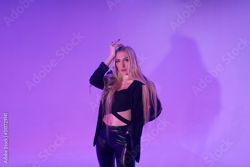 Attractive blonde woman sitting on the chair over pink background