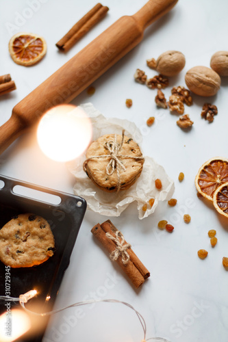 Christmas composition. cookies tied  rolling pin  cinnamon  cookies and dried orange  nuts  raisins. The view from the top