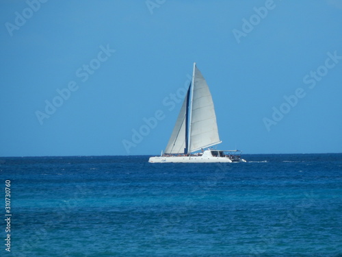 Velero con fiesta en medio del mar caribe y un lindo fondo del cielo