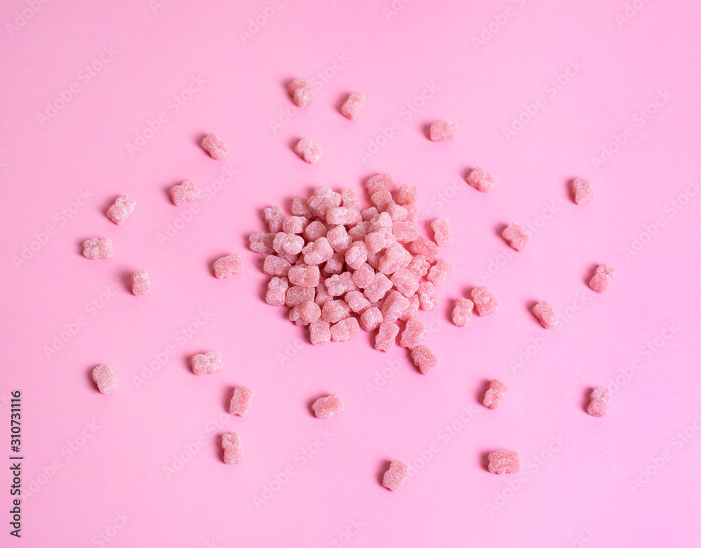 Pink vitamins in the shape of a bear on a pink background. It's like sweet marmalade in sugar.