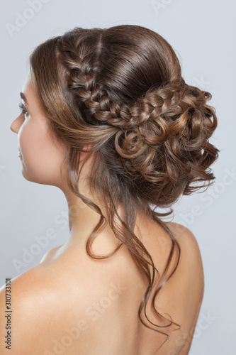 Portrait of a beautiful sensual light brown haired woman with a wedding hairstyle and nude make-up in a beauty salon. Wedding hairstyle.