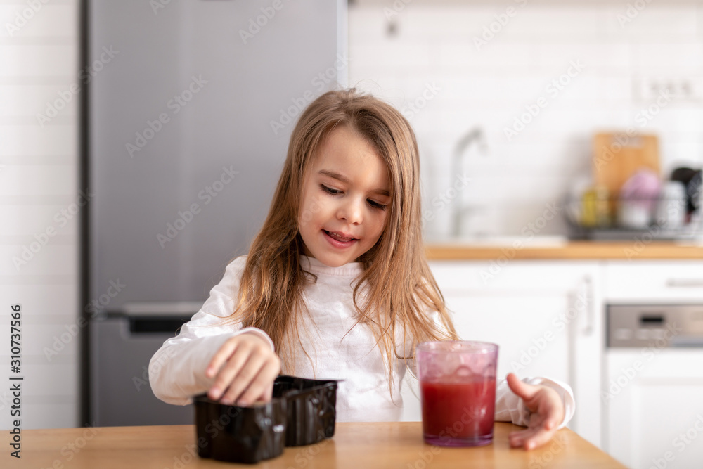 Young girl eating cookies and playing on her tablet Young girl eating cookies and playing on her tablet