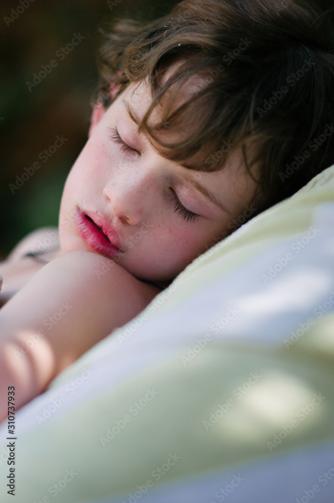 Close up child asleep in a garden on a hot summer afternoon Close up child asleep in a garden on a hot summer afternoon
