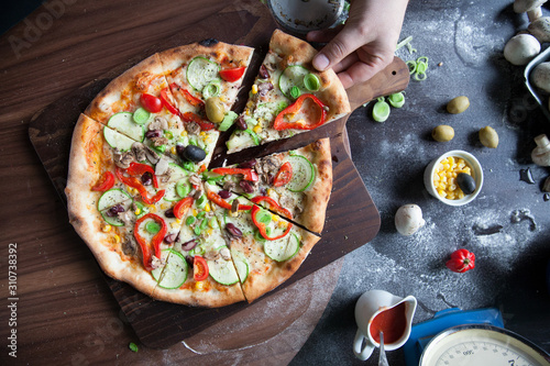 Italian pizza with red peppers, corn and cucumber photo