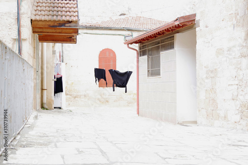 Black laundry hanging on a rope between houses in the courtyard of the ancient city