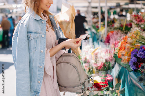 Unrecognizable woman buying flowers at market