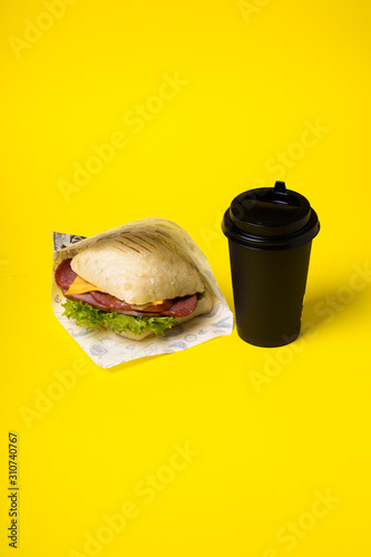 Sandwich and coffee on the yellow background. Fastfood. Burgeer.