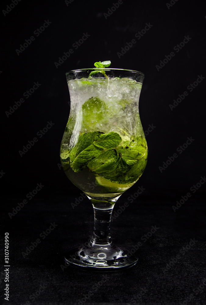 Mojito with lime, mint and ice. a beautiful cocktail on an isolated, black background. Mojito with lime, mint and ice. a beautiful cocktail on an isolated, black background.